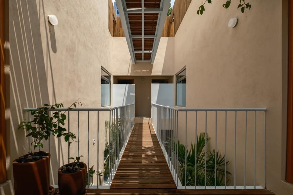 Un puente de acero cruza el pozo de luz entre plantas