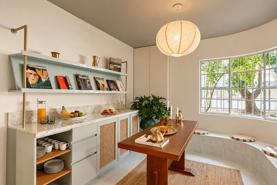 Bookshelves, a wooden table and the curved window of the common room