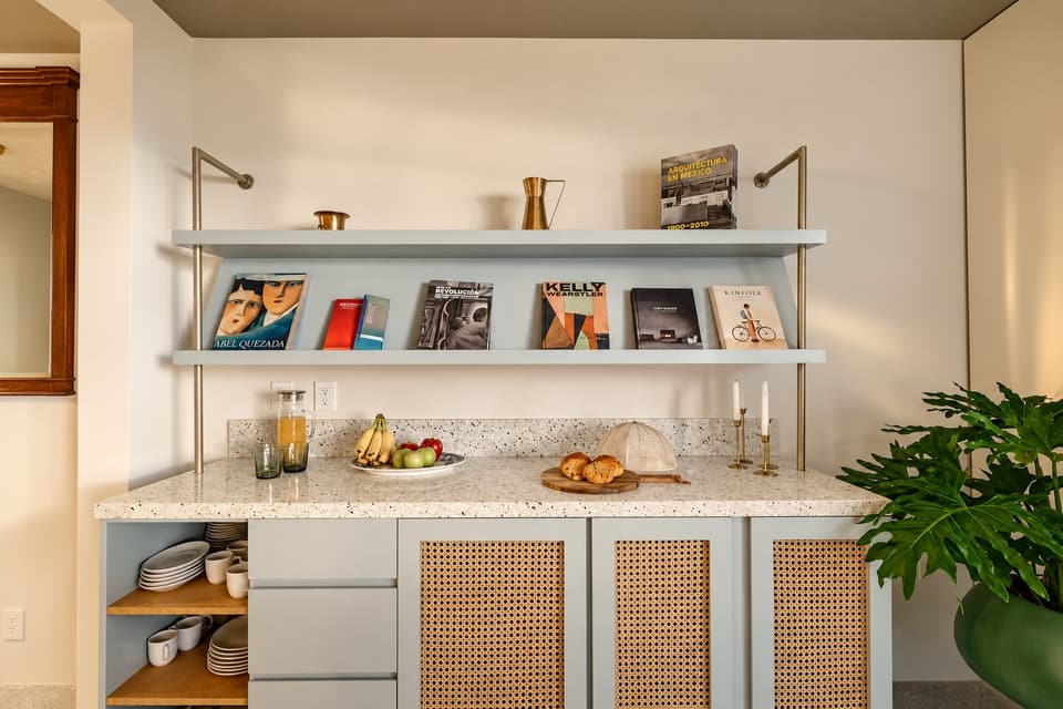 Bookshelves over a cabinet with cane doors