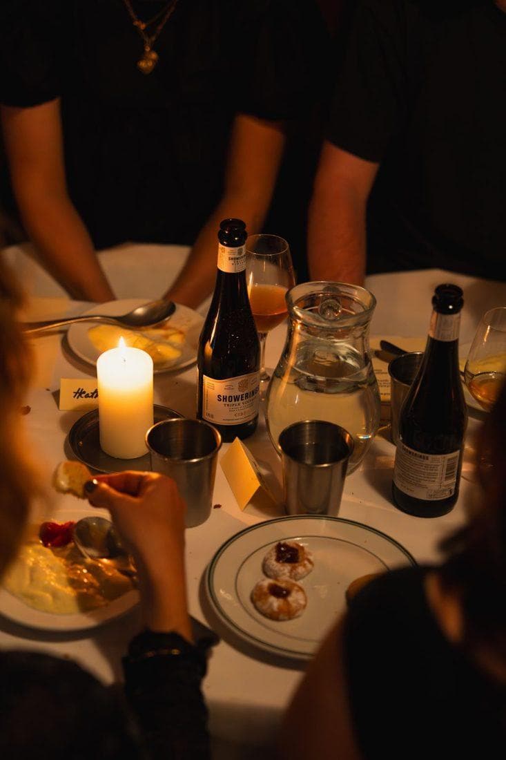 Una mesa de noche a la luz de una vela, con copas y botellas