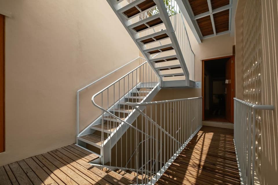 La escalera de acero blanca que sube por el pozo de luz